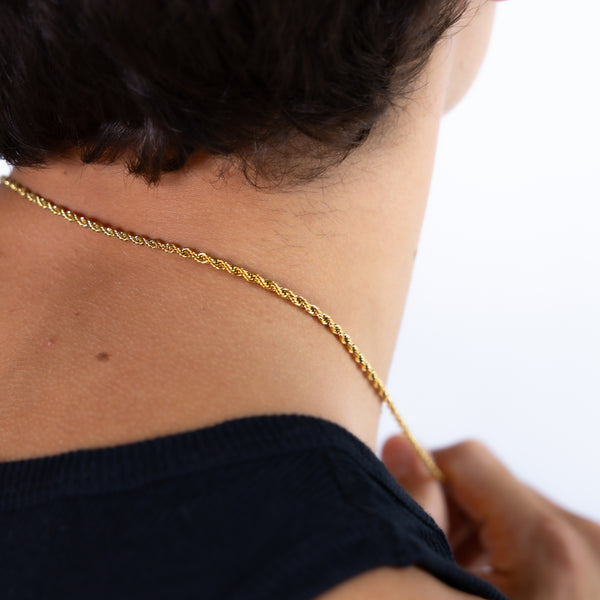 Gold rope chain necklace worn around the neck, back view