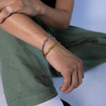 5mm gold and silver figaro chain bracelets worn on the wrist, close-up view