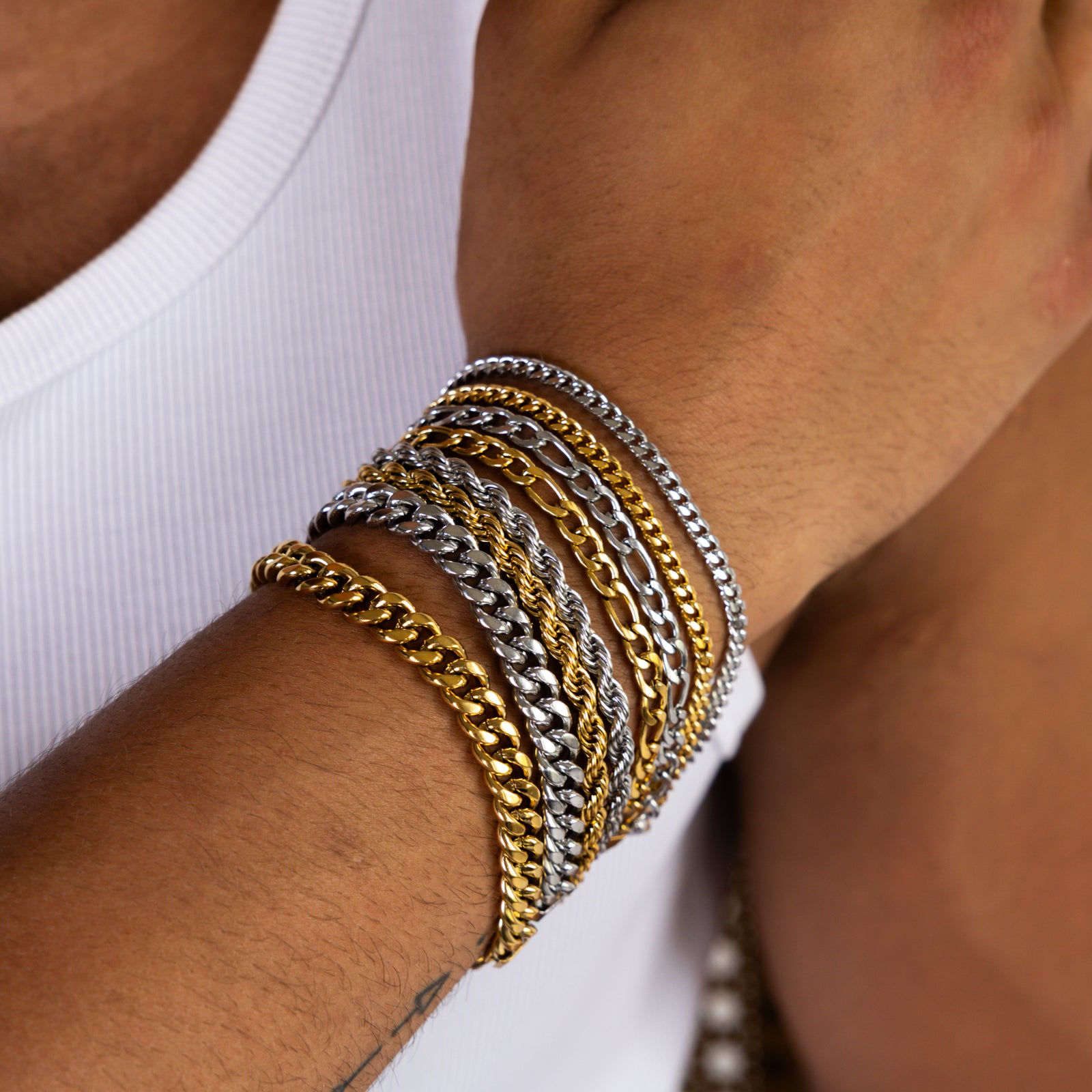 5mm gold and silver assorted chain bracelets worn on the wrist, close-up view