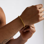 5mm gold wheat chain bracelet worn on the wrist, close-up view