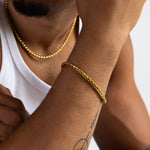 5mm gold wheat bracelet and matching necklace worn with a white tank top, close-up view