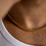 5mm gold wheat chain necklace worn around the neck whilst weaing white vest, close-up view
