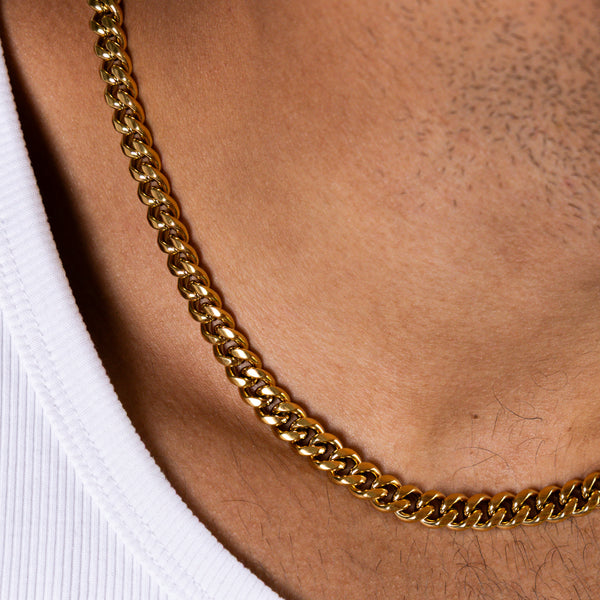 Close-up side view of an 8mm gold Cuban chain necklace worn around the neck