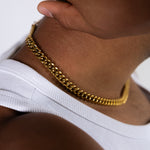 Close-up side view of an 8mm gold Cuban chain necklace worn around the neck