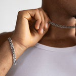 8mm silver Cuban bracelet and matching chain worn with a white tank top, close-up view