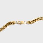 Gold chain clasp shot on a light grey background