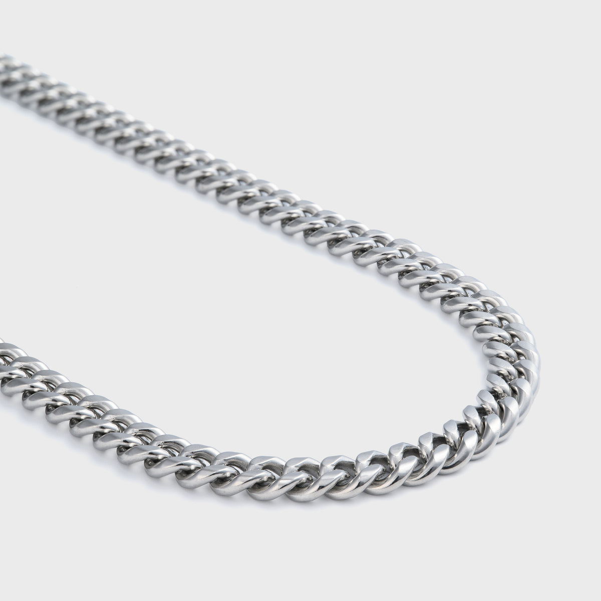 Side shot of silver cuban chain on grey background