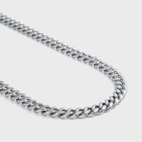 Side shot of silver cuban chain on grey background