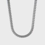 Silver chain necklace on a light grey background