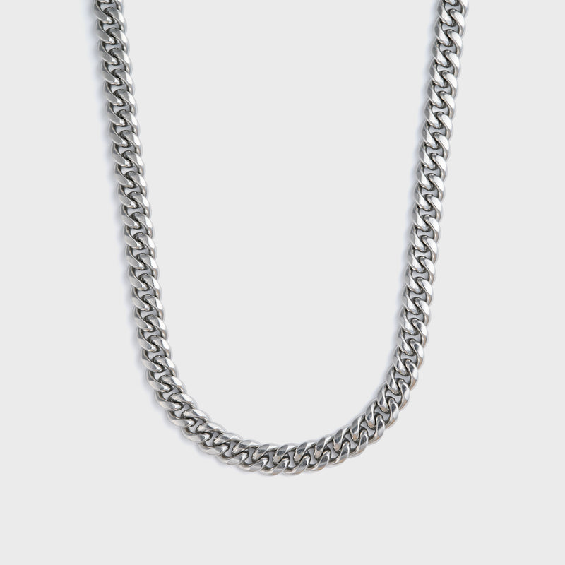 Silver chain necklace on a light grey background