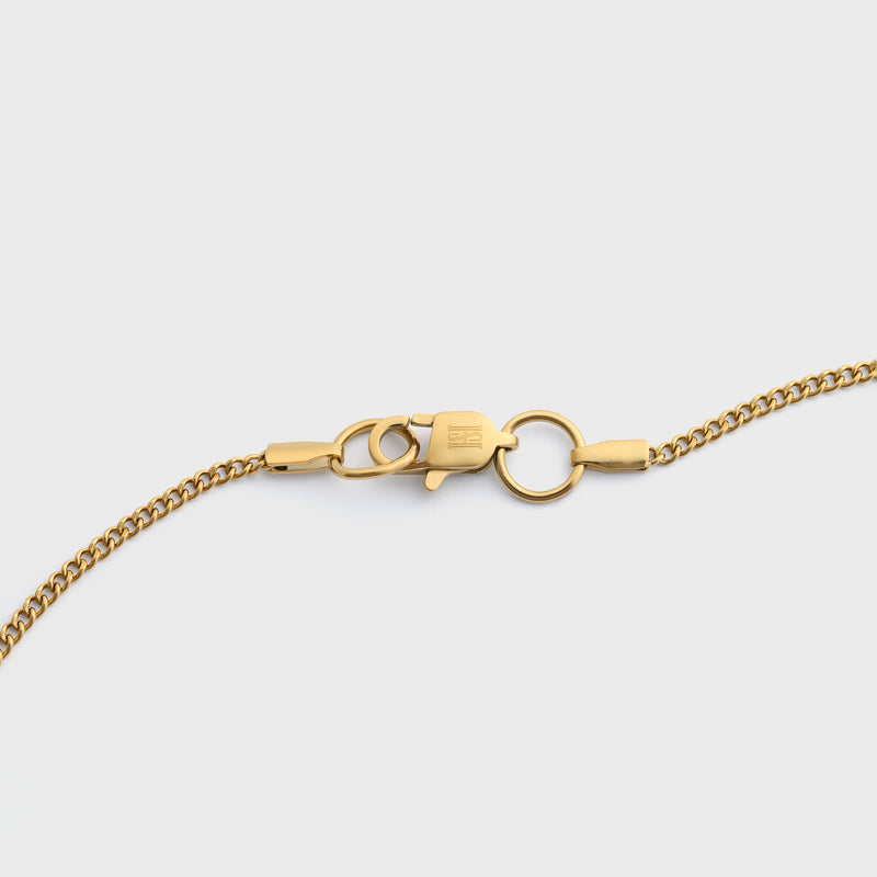 Curb chain gold clasp shot on light grey background