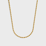 Gold rope chain necklace on a light grey background