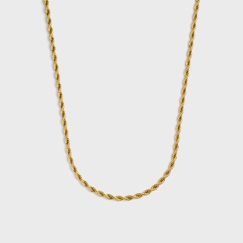 Gold rope chain necklace on a light grey background