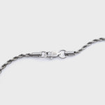 Silver rope chain clasp shot on a light grey background