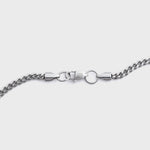 Silver chain necklace on a light grey background