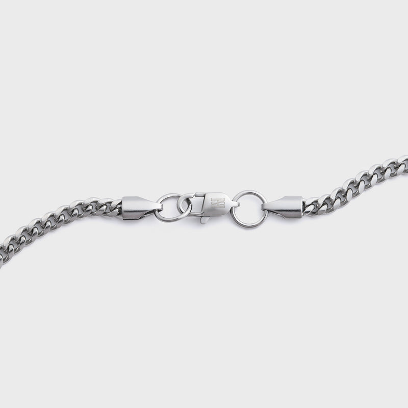 Silver chain necklace on a light grey background