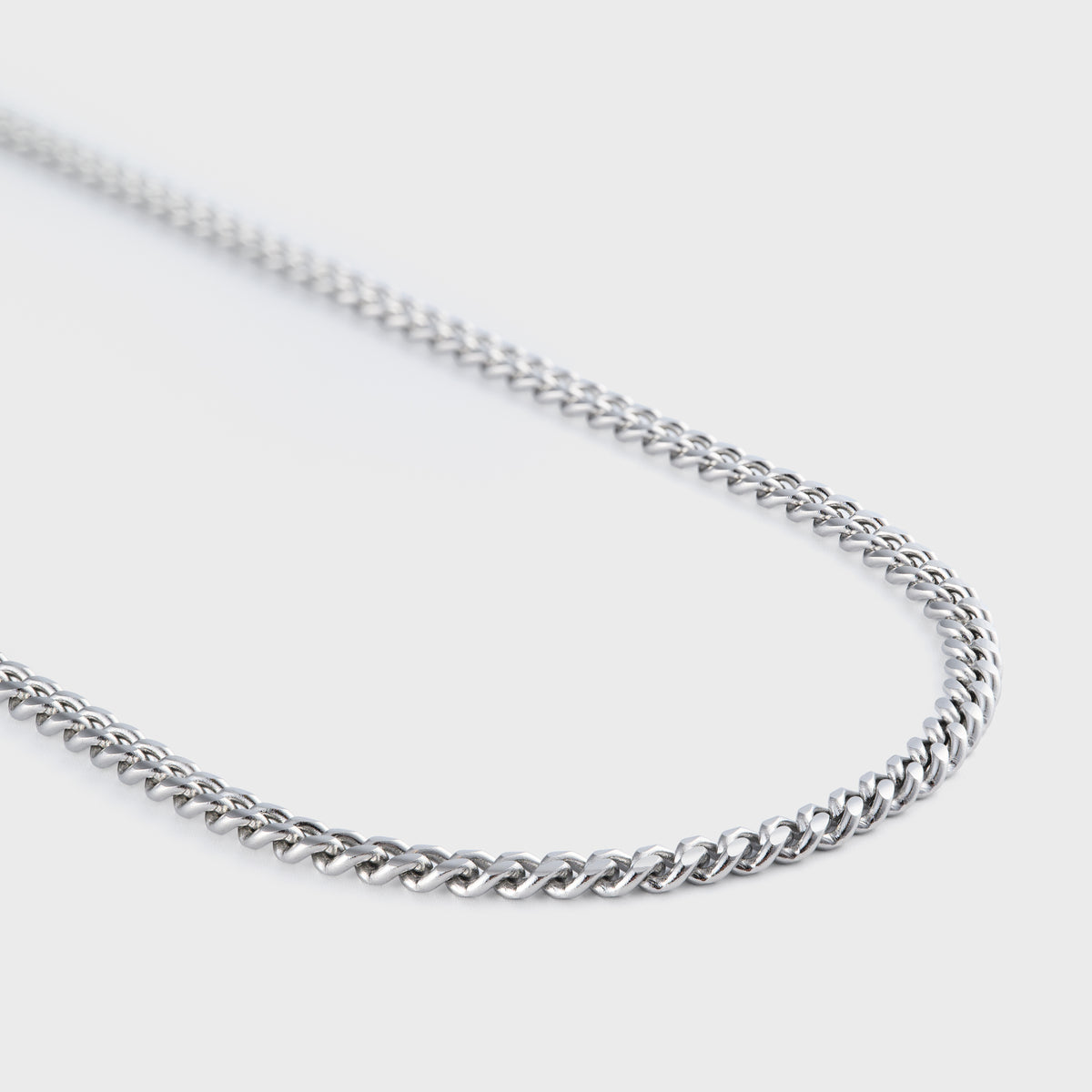 Silver chain necklace on a light gray background
