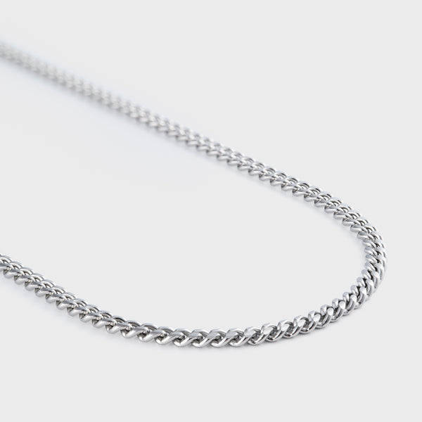 Silver chain necklace on a light gray background