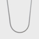 Silver chain necklace on a light gray background