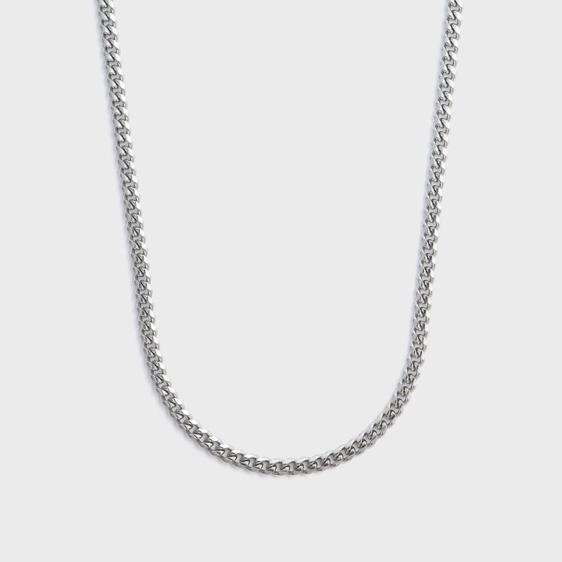 Silver chain necklace on a light gray background